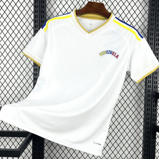 White sports jersey with 'Venezuela' text on a hanger against a black grid background